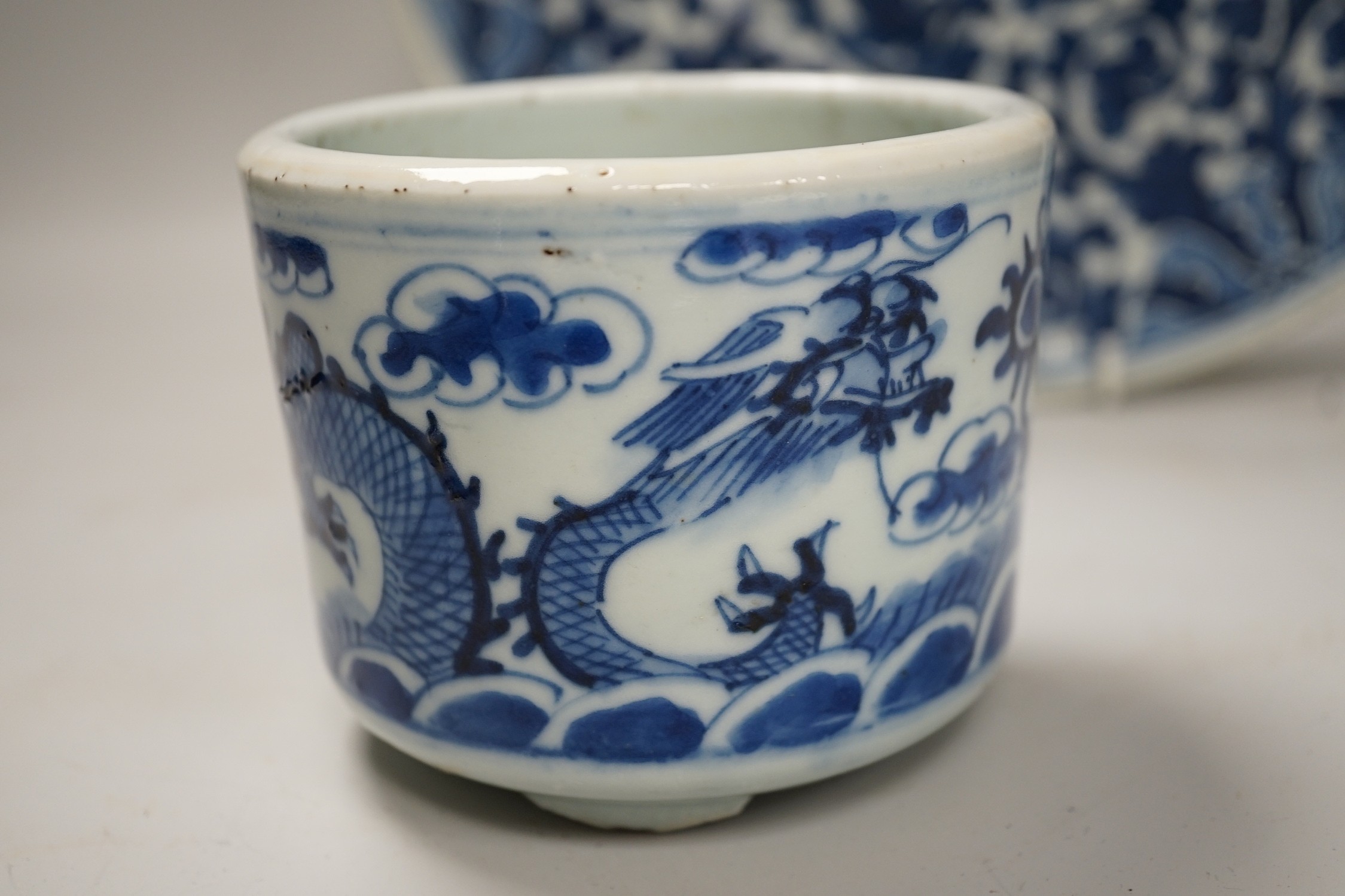 A Chinese blue and white ‘lotus’ charger, together with a bowl and dragon pot on tripod base